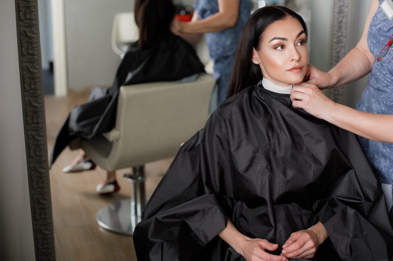 Tranquil woman is doing hair in salon